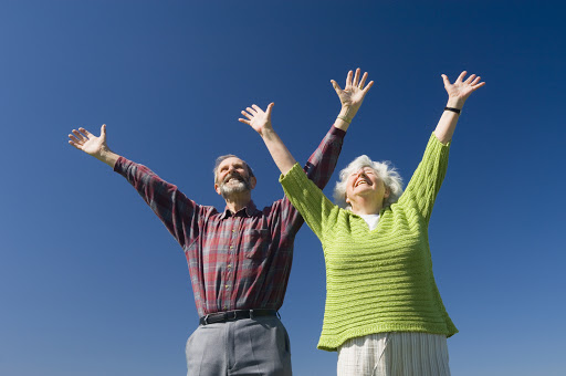 seniors jumping with hands over head