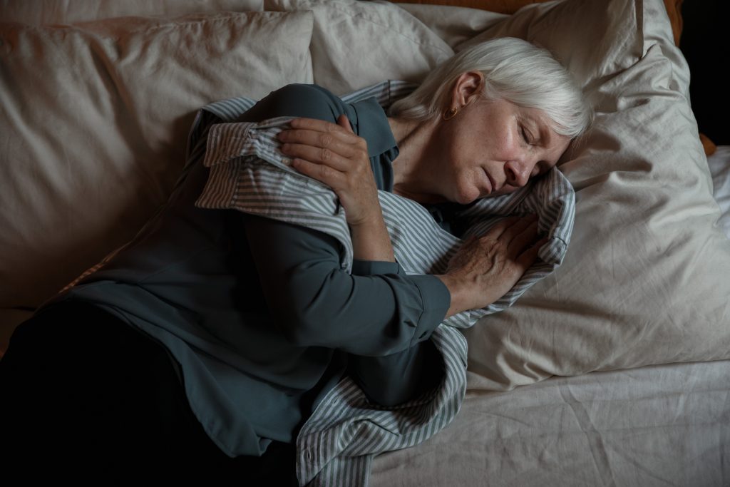 An elderly woman lying on the bed
