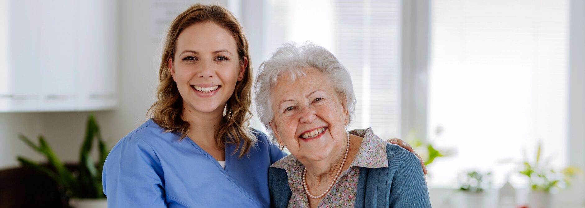 young female caregiver with older female client in wheelchair